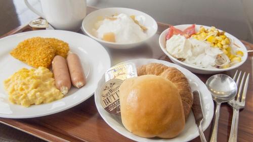 una tavola con piatti e ciotole di cibo di Hearton Hotel Higashi-Shinagawa a Tokyo