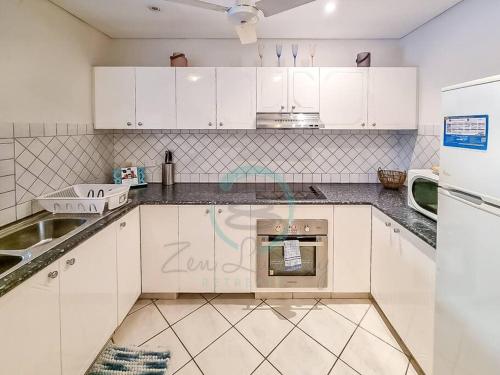 a kitchen with white cabinets and an oven at ZEN CITY Modern 1-BR City Apt Near Mindal Markets in Larrakeyah
