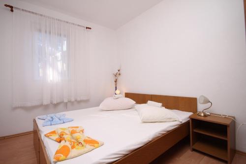 a bedroom with a bed with white sheets and a window at Apartments by the sea Ivan Dolac, Hvar - 8782 in Ivan Dolac
