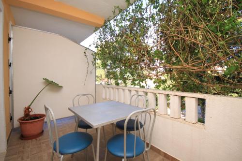 einen Tisch und Stühle auf einem Balkon mit Pflanzen in der Unterkunft Apartments by the sea Ivan Dolac, Hvar - 8782 in Ivan Dolac