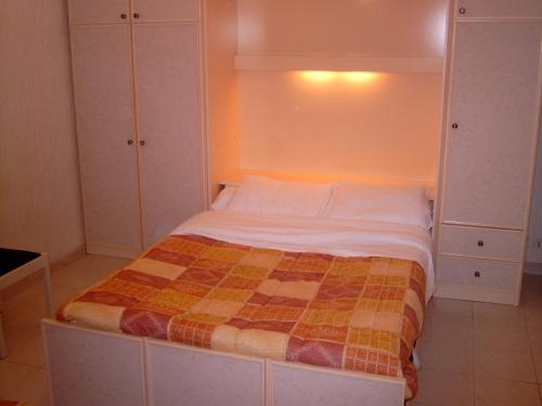 um pequeno quarto com uma cama num quarto em La Victoire em Fréjus