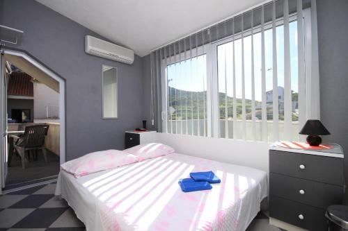 a bedroom with a bed and a large window at Apartments with a parking space Hvar - 8810 in Hvar
