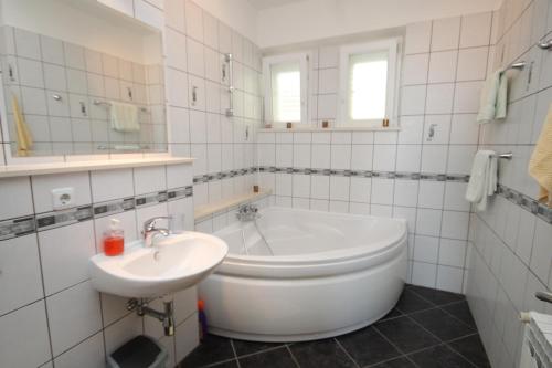 La salle de bains blanche est pourvue d'une baignoire et d'un lavabo. dans l'établissement Apartments and rooms with parking space Mlini, Dubrovnik - 8994, à Mlini