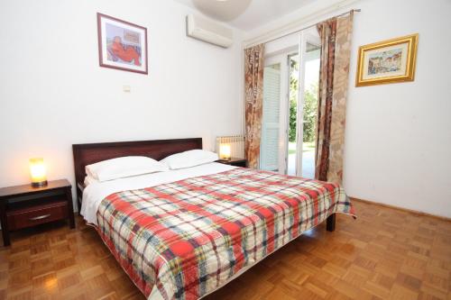 - une chambre avec un lit et une couverture tressée dans l'établissement Apartments and rooms with parking space Mlini, Dubrovnik - 8994, à Mlini