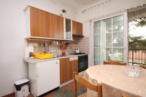a kitchen with a table and a white refrigerator at Apartments with a parking space Jelsa, Hvar - 538 in Jelsa