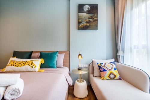 um quarto com 2 camas e um sofá em 2BR Designer's villa at La Habana Huahin em Hua Hin