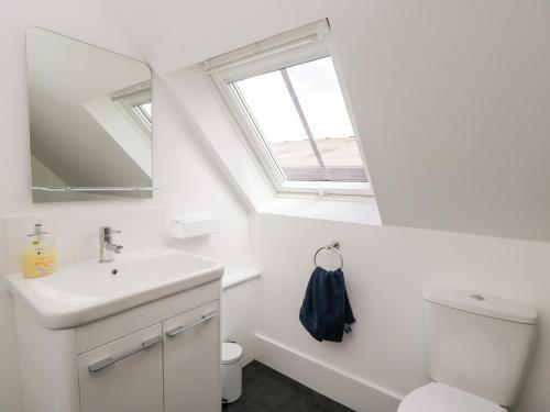 La salle de bains est pourvue d'un lavabo, de toilettes et d'une fenêtre. dans l'établissement The Old Stable, à Witney