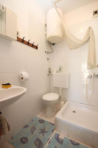 a bathroom with a toilet and a sink and a tub at Apartments by the sea Rukavac, Vis - 1154 in Vis