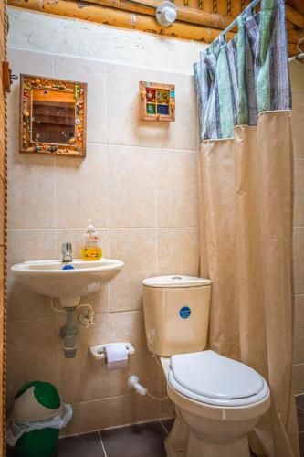 a bathroom with a toilet and a sink at Villa Celina: La cabañita de Guadua in Santa Elena