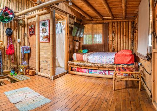 1 dormitorio con 1 cama en una cabaña de madera en Villa Celina: La cabañita de Guadua, en Santa Elena