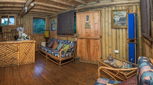a living room with a couch and chairs in a cabin at Villa Celina: La cabañita de Guadua in Santa Elena