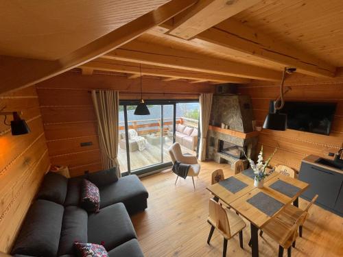 a living room with a couch and a table at Domek drewniany w górach Jacuzzi & Balia - Osada Chełm in Stróża