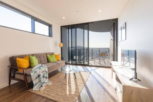 a living room with a couch and a balcony at AirTrip Apartments at South Brisbane in Brisbane