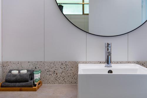 a bathroom with a sink and a mirror at Ocean View Apartment 49 in Airlie Beach