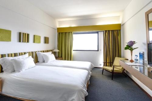 a hotel room with two beds and a window at Hotel Golf Mar in Maceira