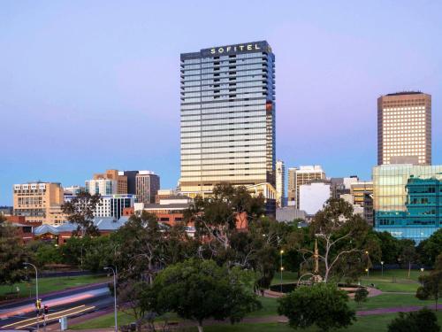 um horizonte da cidade com um edifício alto em primeiro plano em Sofitel Adelaide em Adelaide