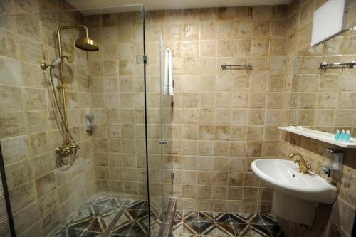 a bathroom with a shower and a sink at Hotel Verisima in Tbilisi City