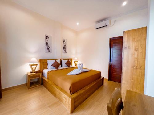 チャングーにあるThe Manggar Guesthouseのタオルが敷かれたベッドのある寝室