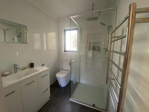 een badkamer met een douche, een toilet en een wastafel bij Tranquil on Churchill Linen included Pet friendly Wifi in Inverloch