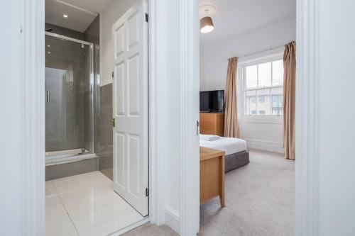 a bedroom with a bed and a bathroom with a window at Premium Apartments over looking Canary Wharf Towers in London