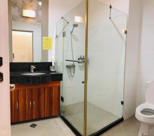 a bathroom with a glass shower and a toilet at Queens Island Golf and Resort in Medellin