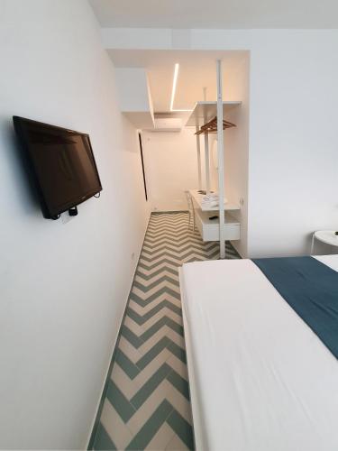 a bedroom with a bed and a flat screen tv at La Casa di Mina in Monte di Procida