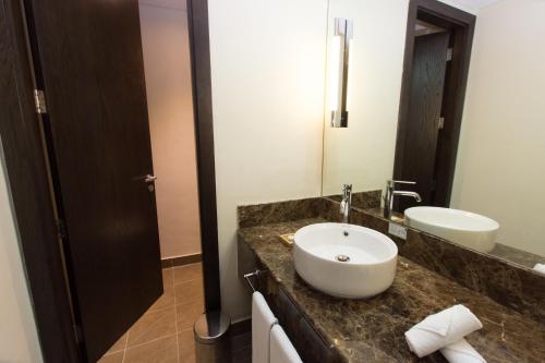 a bathroom with two sinks and a mirror at Holiday Inn Abu Dhabi, an IHG Hotel in Abu Dhabi