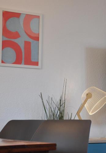 a table with a lamp and a plant on a wall at Gemütliche Dachwohnung mit kleiner oder großer Dachterrasse nebeneinander in Wolmirstedt