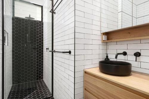 a bathroom with a black sink and a shower at The Stables at the Hill in Newcastle