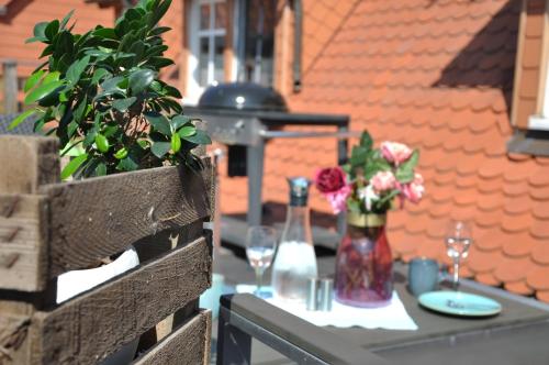 a table with a vase of flowers and wine glasses at Gemütliche Dachwohnung mit kleiner oder großer Dachterrasse nebeneinander in Wolmirstedt