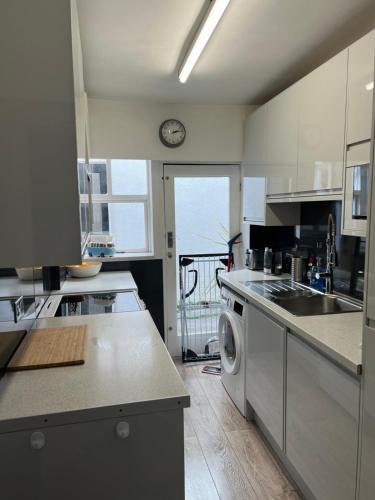 a kitchen with a sink and a washing machine at Casa Cozy in Torquay