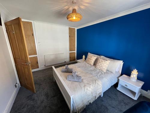 a blue bedroom with a bed and a blue wall at Casa Cozy in Torquay