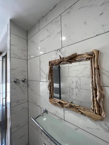 a bathroom with a mirror and a bath tub at Casa Cozy in Torquay