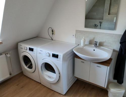 uma casa de banho com uma máquina de lavar roupa e um lavatório em Gemütliche Dachwohnung mit kleiner oder großer Dachterrasse nebeneinander em Wolmirstedt