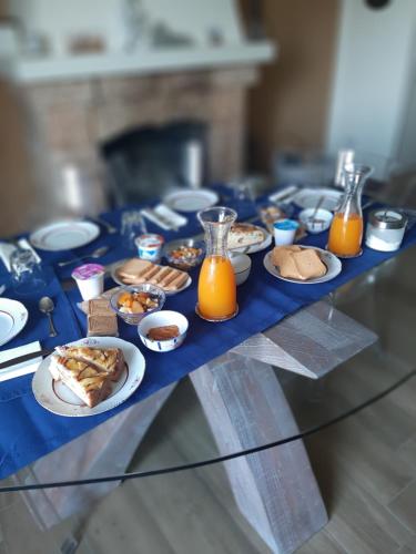 a table topped with plates of food and orange juice at B&B degli Allori in Moggiona