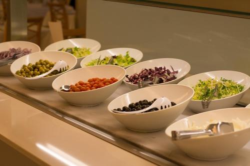 a buffet with bowls of different types of vegetables at Hotel Sabina in Cala Millor