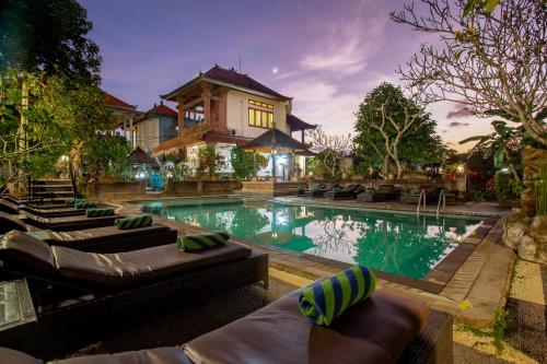 a house with a swimming pool in front of a house at Nick's Pension in Ubud