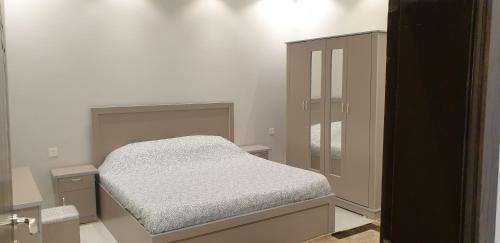 um pequeno quarto com uma cama e um armário em مزرعة الكرم الحاتمي em Al Shafa
