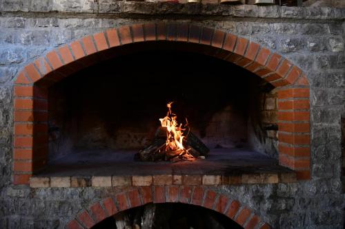 a brick oven with a fire in it at Deluxe Apartments Franjkovic in Seliste Dreznicko