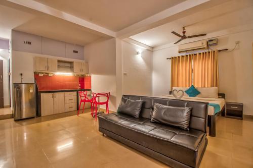 a living room with a couch and a kitchen at Villa Verediana in Candolim
