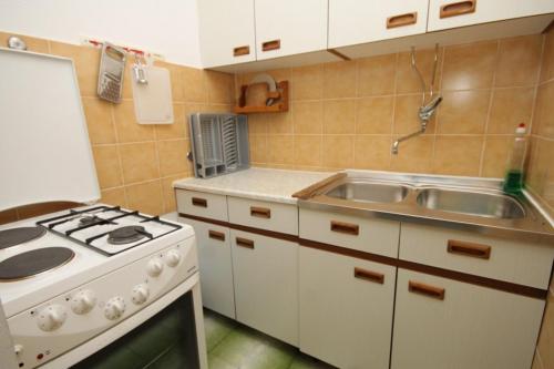 een kleine keuken met een fornuis en een spoelbak bij Apartments with a parking space Komiza, Vis - 8866 in Komiža