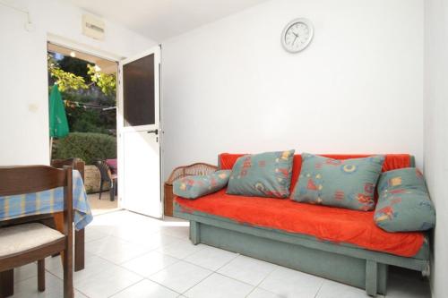 a red couch with blue pillows in a living room at Apartments with a parking space Vis - 8938 in Vis