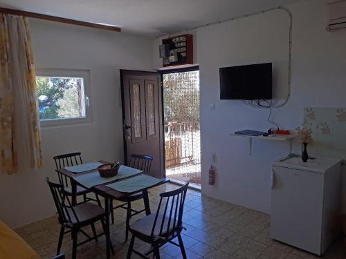 ein Esszimmer mit einem Tisch, Stühlen und einem TV in der Unterkunft Apartments with a parking space Zavala, Hvar - 8912 in Zavala