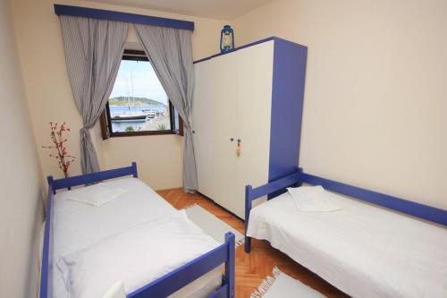 two beds in a room with a window at Apartments by the sea Vis - 8875 in Vis