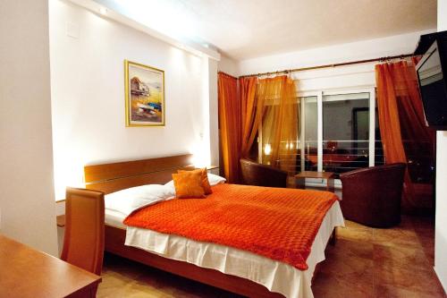 ein Schlafzimmer mit einem Bett mit einer orangefarbenen Decke in der Unterkunft Luxury villa with a swimming pool Vis - 8922 in Vis