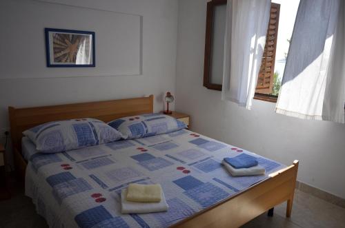a bedroom with a bed with two towels on it at Apartments by the sea Milna, Vis - 8943 in Rukavac