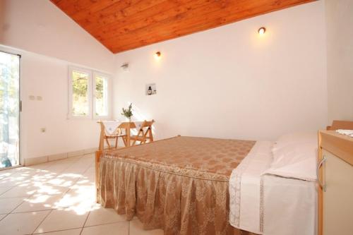 a bedroom with a bed and a table at Studio Podspilje 8915a in Vis