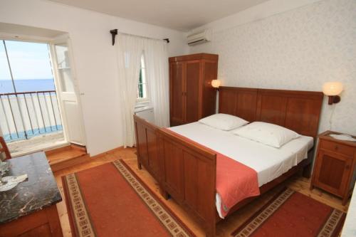 - une chambre avec un lit et une grande fenêtre dans l'établissement Apartments and rooms by the sea Komiza, Vis - 8910, à Komiža