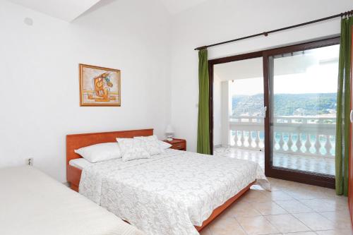 Un dormitorio con una cama y una ventana grande en Apartments by the sea Marina, Trogir - 9037, en Marina