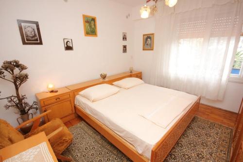 ein Schlafzimmer mit einem Bett, einem Stuhl und einem Fenster in der Unterkunft Apartments by the sea Vis - 8906 in Vis